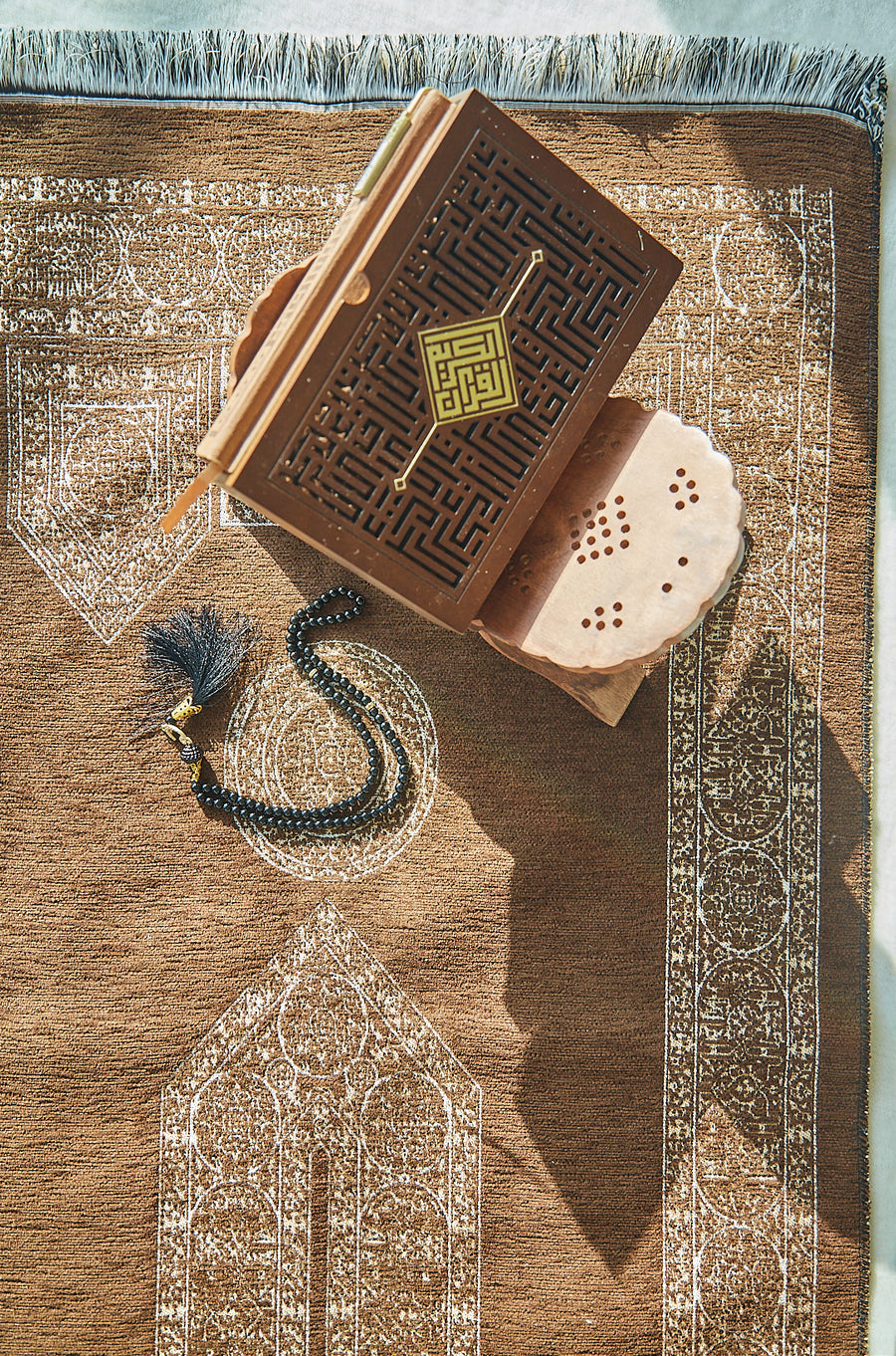 Mecca Collection prayer mat styled with Quran and prayer beads, overhead view