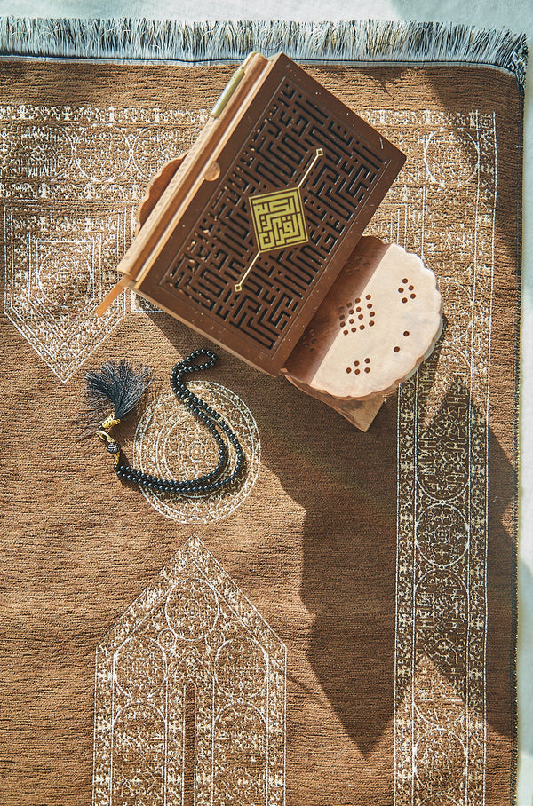 Mecca Collection prayer mat styled with Quran and prayer beads, overhead view