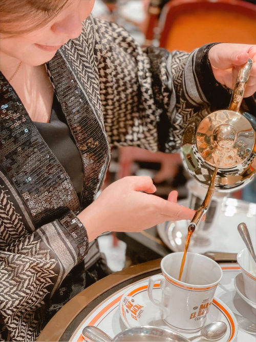 Chestnut Keffiyeh Kimono worn at a tea gathering — lifestyle detail of the keffiyeh weave