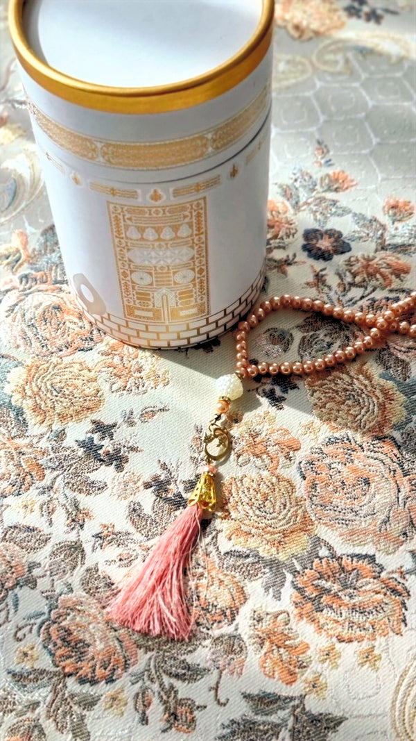 Safia floral sajadah styled with gold canister and pink-tassel tasbih