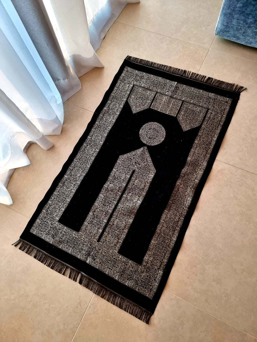 Black Oud Mecca Collection prayer mat placed by the window — woven sajadah