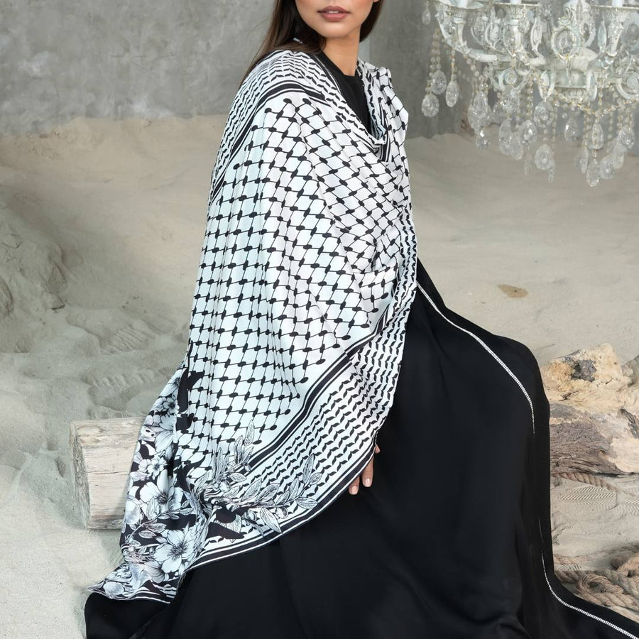 Olive Floral Keffiyeh Scarf styled over a black abaya, seated pose