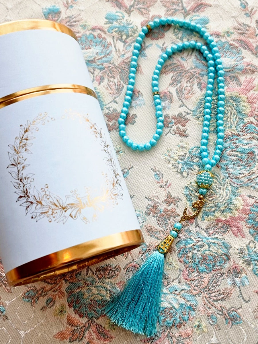 Safia floral prayer mat styled with turquoise prayer beads