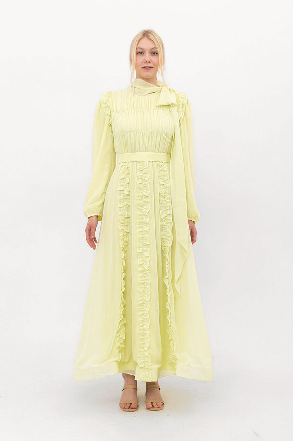 Model wearing the Ethereal Edit chiffon modest dress in soft Primrose yellow, full-length front view showing flowing sleeves and hemline.